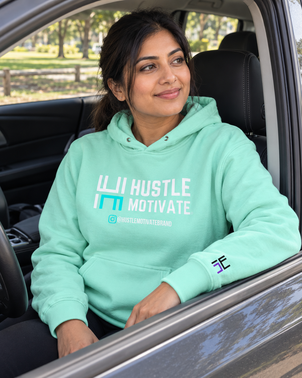 AI lifestyle mockup of the Mint Hustle Motivate hoodie worn in a parked car.