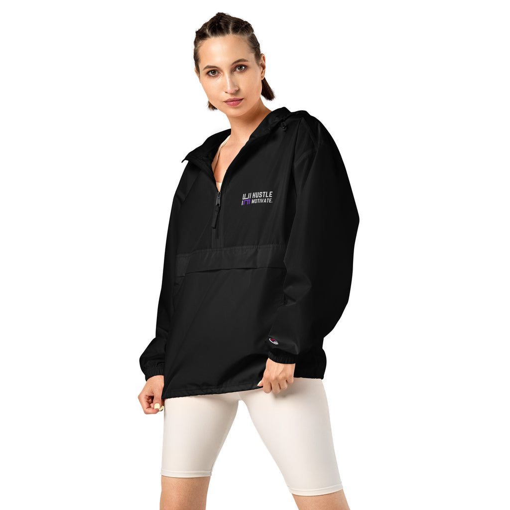 Model wearing the black Hustle Motivate Packable Windbreaker with cream cycling shorts.