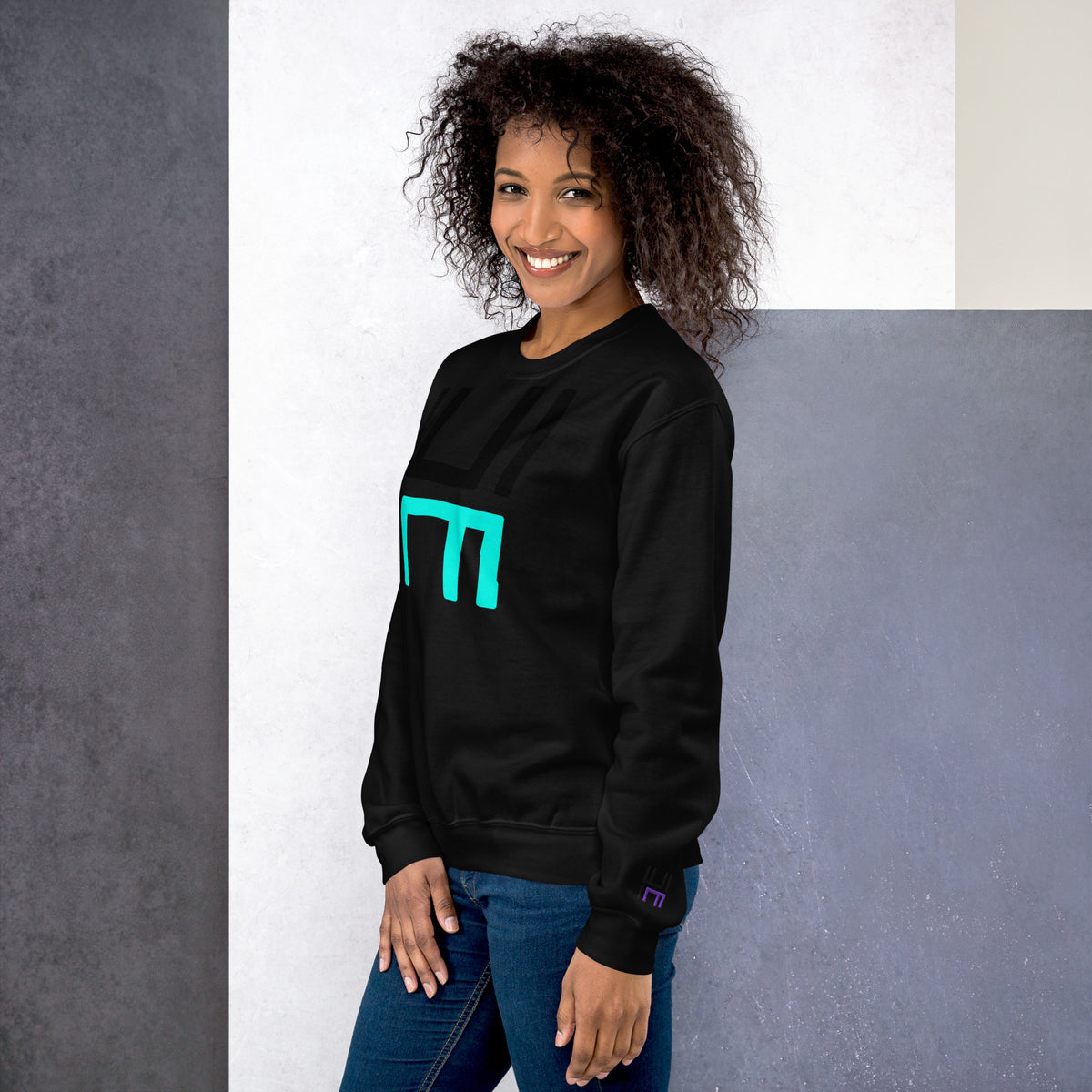 Model wearing the Hustle Motivate Statement Crewneck in black, showing the front print and embroidered left sleeve