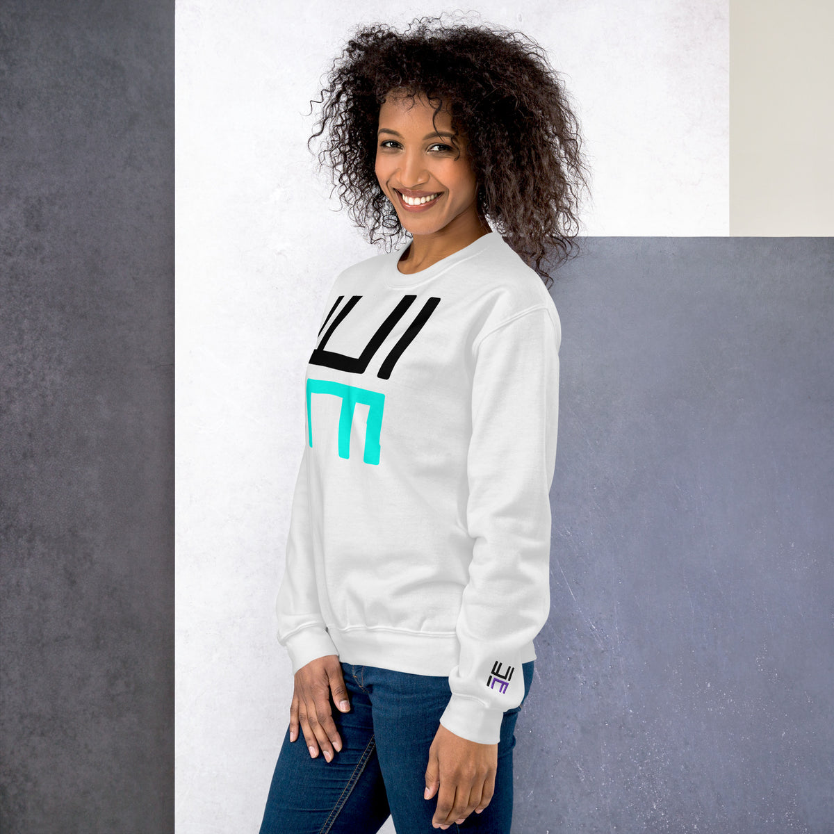 Model wearing the Hustle Motivate Statement Crewneck in white, showing the front print and embroidered left sleeve